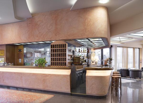 Reception di un hotel con bar e area salotto elegante.