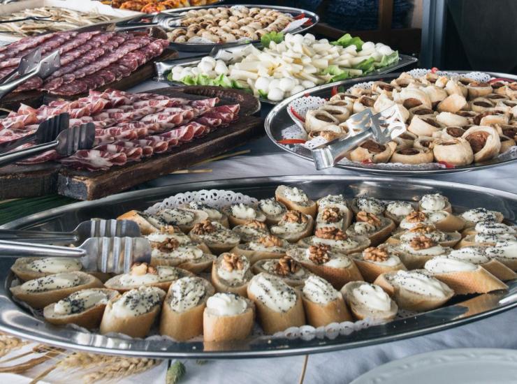 Buffet with cured meats, cheeses, and various appetizers on trays.